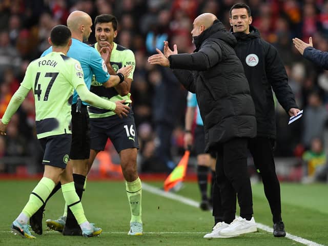 Manchester City manager Pep Guardiola and his players surround referee Anthony Taylor as he goes to the screen to look at a VAR review ahead of his disallowing Phil Foden’s goal (Photo by OLI SCARFF/AFP via Getty Images)