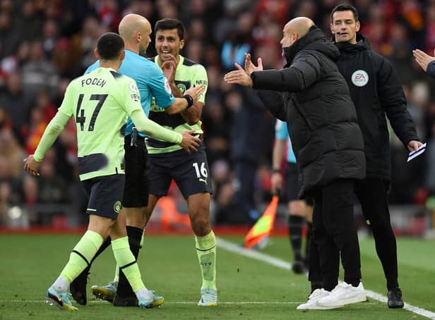 <p>Manchester City manager Pep Guardiola and his players surround referee Anthony Taylor as he goes to the screen to look at a VAR review ahead of his disallowing Phil Foden’s goal (Photo by OLI SCARFF/AFP via Getty Images)</p>