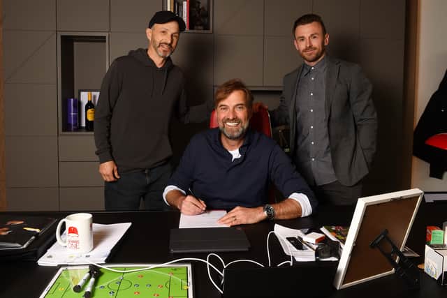 Jurgen Klopp manager of Liverpool signing a contract extension with Michael Gordon President of Fenway Sports Group and Julian Ward assistant sporting director  of Liverpool at AXA Training Centre on April 28, 2022 in Kirkby, England. (Photo by Andrew Powell/Liverpool FC via Getty Images)