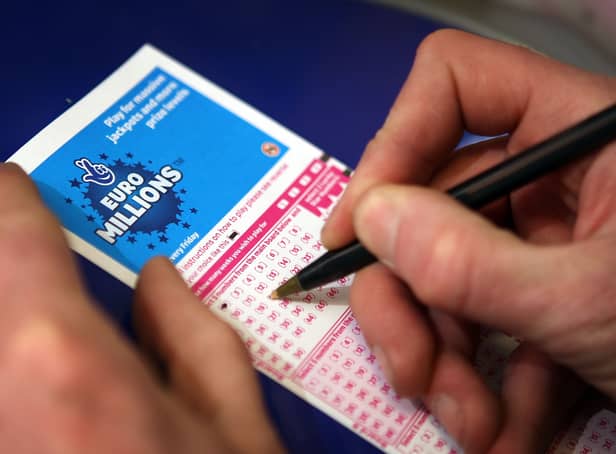 <p> A punter fills out a National Lottery ticket.</p>