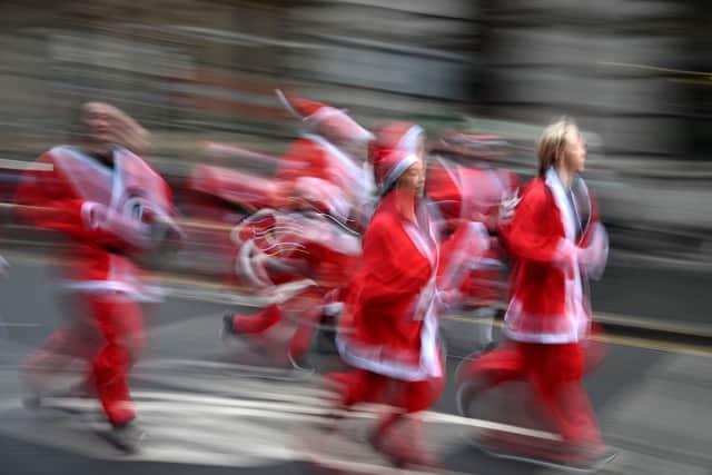 Runners dressed in Father Christmas take part in the annual five-kilometre Santa Dash. (Photo by OLI SCARFF/AFP via Getty Images)