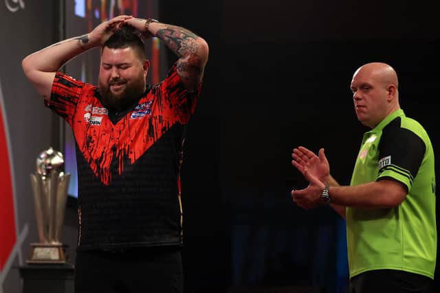England's Michael Smith (L) reacts after winning the PDC World Darts Championship final match against Netherlands' Michael van Gerwen at Alexandra Palace in London on January 3, 2023. (Photo by Adrian DENNIS / AFP) (Photo by ADRIAN DENNIS/AFP via Getty Images)