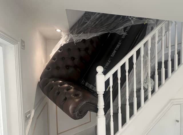 The sofa stuck on the stairs. See SWNS story SWLNsofa. A homeowner has slammed a furniture company after they abandoned a failed attempt to deliver new sofa - leaving it jammed on the stairs. Luke Ansell, 27, had just moved in to his brand new £500k home in Bournemouth in December when he bought an over £2,000 sofa that was delivered on January 19. Despite delivery-men assuring him that they made tight deliveries 'all the time' - the pair from designersofasforyou.co.uk failed to get the new sofa-bed up a narrow staircase, before abandoning it. Photos of the shocking attempted delivery show how the pair left huge holes in the staircase plasterwork, and damage to the woodwork, before leaving.