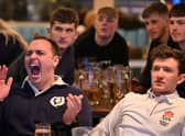A Scotland fan celebrates while surrounded by England fans during the Scotland v England at the Bambalan bar on February 5, 2022 in Bristol, England. 