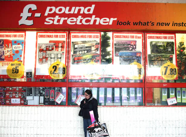 <p>A woman waits outside a branch of Poundstretcher near Lewisham high street.</p>