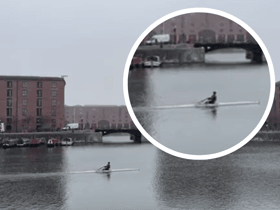 A man casually rowing on the Albert Dock as snow hits Liverpool. Image Emma Dukes
