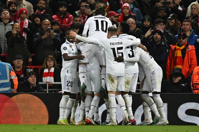 Karim Benzema is mobbed by teammates after scoring Madrid’s third goal at Anfield (Photo by PAUL ELLIS/AFP via Getty Images)