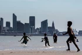 People enjoy the warm weather and sunshine on New Brighton beach and promenade with the Liverpool skyline behind. Image: Christopher Furlong/Getty Image