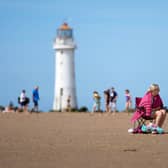 People enjoy the warm weather and sunshine on New Brighton beach and promenade. Image: Christopher Furlong/Getty Images