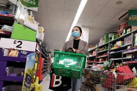 A shopper wears a protective mask as she walks down an aisle in a supermarket (Getty Images)