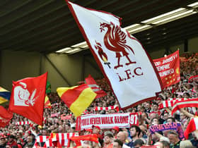 Liverpool fans hold up flags and scarfs in the stands ahead of a match