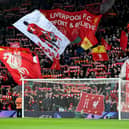 Liverpool fans holding banners and flags in the Kop