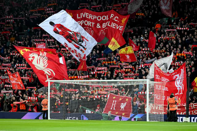 Liverpool fans holding banners and flags in the Kop