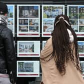 People look at residential properties displayed for sale in the window of an estate agents. Photo by Isabel Infantes/AFP via Getty Images. 
