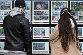 People look at residential properties displayed for sale in the window of an estate agents. Image: ISABEL INFANTES/AFP via Getty Images