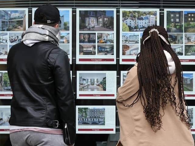 People look at residential properties displayed for sale in the window of an estate agents. Photo by Isabel Infantes/AFP via Getty Images. 
