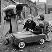 Miss Peggy Robertshaw stops to talk to three children as she walks her daily 12 miles around Liverpool, testing shoes. Peggy works for Dunlop of Speke, and since 1927 has covered over 72,000 miles. Image: Ken Harding/BIPs/Getty Images