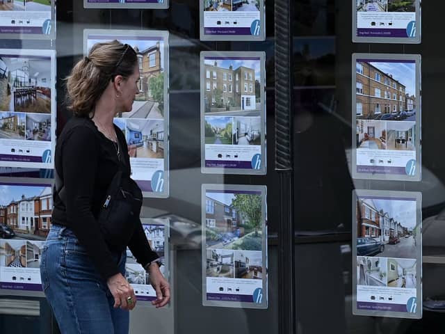 A pedestrians looks at residential properties displayed for sale in the window of an estate agents. Image: JUSTIN TALLIS/AFP via Getty Images