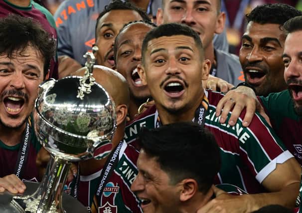 Fluminense’s midfielder Andre Trindade and teammates raise the trophy after winning the Copa Libertadores final. Picture: PABLO PORCIUNCULA/AFP via Getty Images