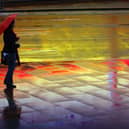 A woman with an umbrella stands in the rain at Liverpool Lime Street. Image: Christopher Furlong/Getty Images