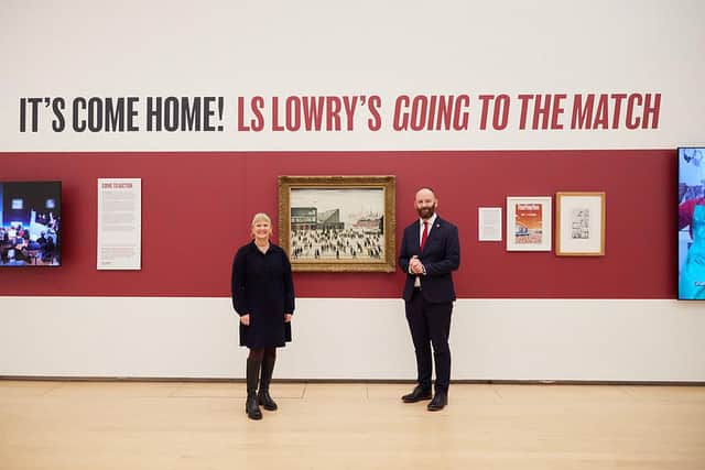 Julia Fawcett, the CEO of The Lowry, and Paul Dennett, Salford City Mayor, with LS Lowry's Going to the Match.