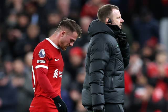 Alexis Mac Allister of Liverpool leaves the pitch with medical staff after receiving treatment during the Premier League match between Liverpool FC and Chelsea FC at Anfield on January 31, 2024 in Liverpool, England. (Photo by Clive Brunskill/Getty Images)