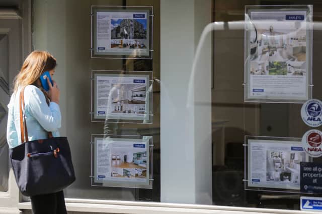 A woman looks for property in an estate agent's window. Picture by AFP via Getty Images