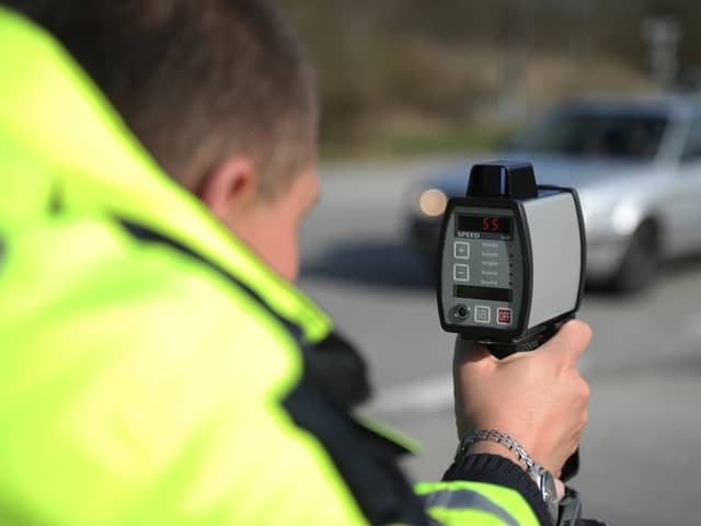 An officer with a handheld speed camera. Image: Benjaminnolte/stock.adobe