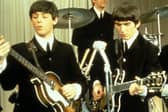 Paul McCartney and George Harrison performing on stage with The Beatles, circa 1963. Image: King Collection/Avalon/Getty Images