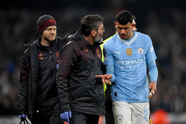 Matheus Nunes of Manchester City leaves the field with his fingers strapped up after sustaining an injury during the UEFA Champions League 2023/24 round of 16 second leg match between Manchester City and F.C. Copenhagen at Etihad Stadium on March 06, 2024 in Manchester, England. (Photo by Shaun Botterill/Getty Images)