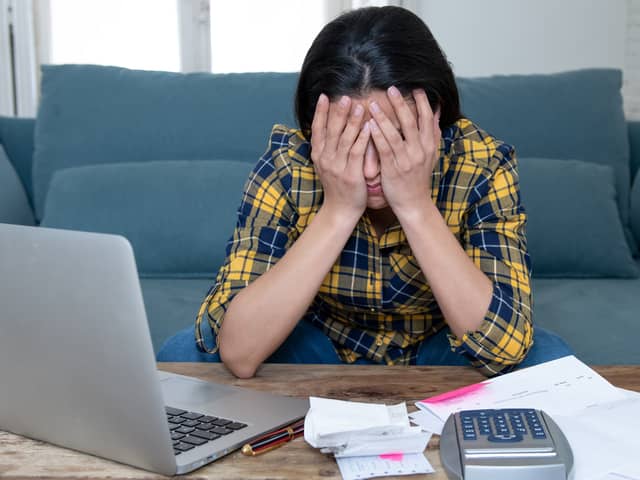 A stressed woman attempts to manage her finances. Image: SB Arts Media/stock.adobe