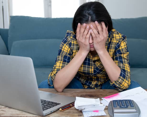 A stressed woman attempts to manage her finances. Image: SB Arts Media/stock.adobe