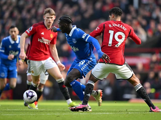 Amadou Onana of Everton is challenged by Raphael Varane