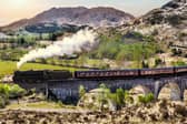 Glenfinnan Railway Viaduct in Scotland with the Jacobite steam train against sunset over lake. Image: Tomas Marek/stock.adobe