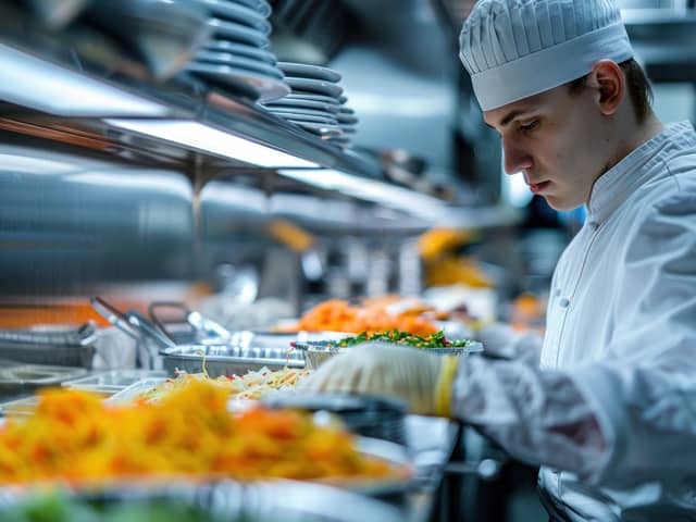 A health and safety inspection in a restaurant focusing on the meticulous examination of kitchen hygiene and food storage. Image: Nisit - stock.adobe.com