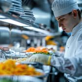 A health and safety inspection in a restaurant focusing on the meticulous examination of kitchen hygiene and food storage. Image: Nisit - stock.adobe.com