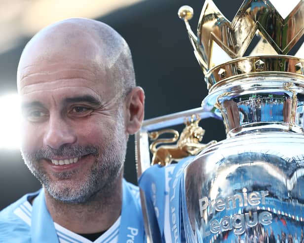 Pep Guardiola celebrates with the Premier League title. (Photo by Naomi Baker/Getty Images)