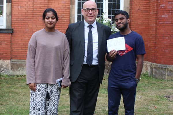 Twins Harsan (L) and Harsha (R) with The Blue Coat School headteacher Kevin Sexton.