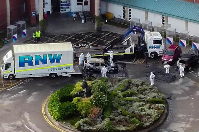 Aerial view of damaged car being removed by forensic officer after the explosion at the Liverpool Women's Hospital