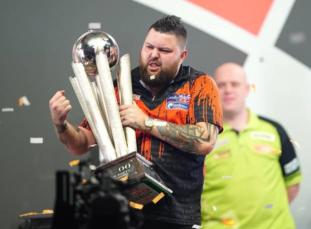 <p>Michael Smith celebrates with the Sid Waddell trophy after winning the final of the Cazoo World Darts Championship against Michael van Gerwen at Alexandra Palace, London.</p>