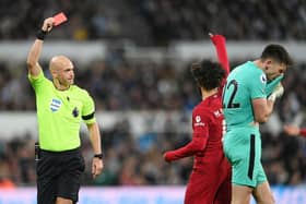 Referee Anthony Taylor shows a red card to Nick Pope of Newcastle United during the Premier League match between Newcastle United and Liverpool FC at St. James Park on February 18, 2023 in Newcastle upon Tyne, England. (Photo by Stu Forster/Getty Images)