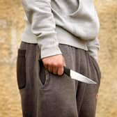PICTURE POSED BY MODEL. A youth with a knife, as the number of people carrying knives has fallen to a nine-year low, according to the figures released by the Government in a Parliamentary answer to Nationalist backbencher Stuart McMillan.
