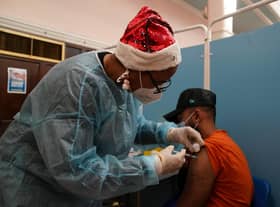 A vaccinator administers a 'Jingle Jab' Covid vaccination booster injection at Redbridge Town Hall, in Ilford, Essex, as the coronavirus booster programme continues across the UK on Christmas day.Picture date: Saturday December 25, 2021.