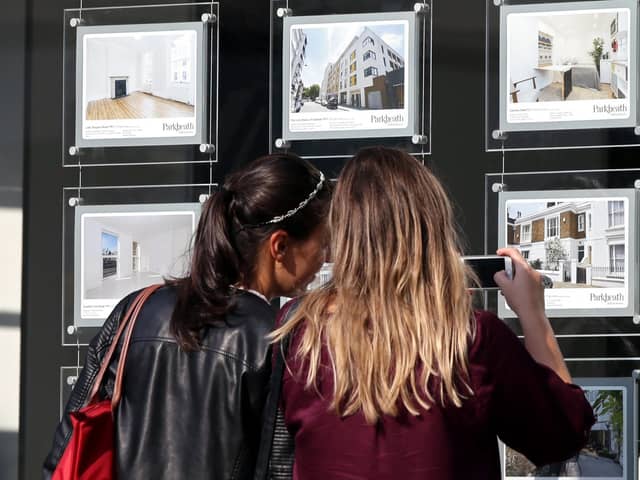 A couple of women studying the house price signs in an estate agents window. Photo: Yui Mok/PA Wire